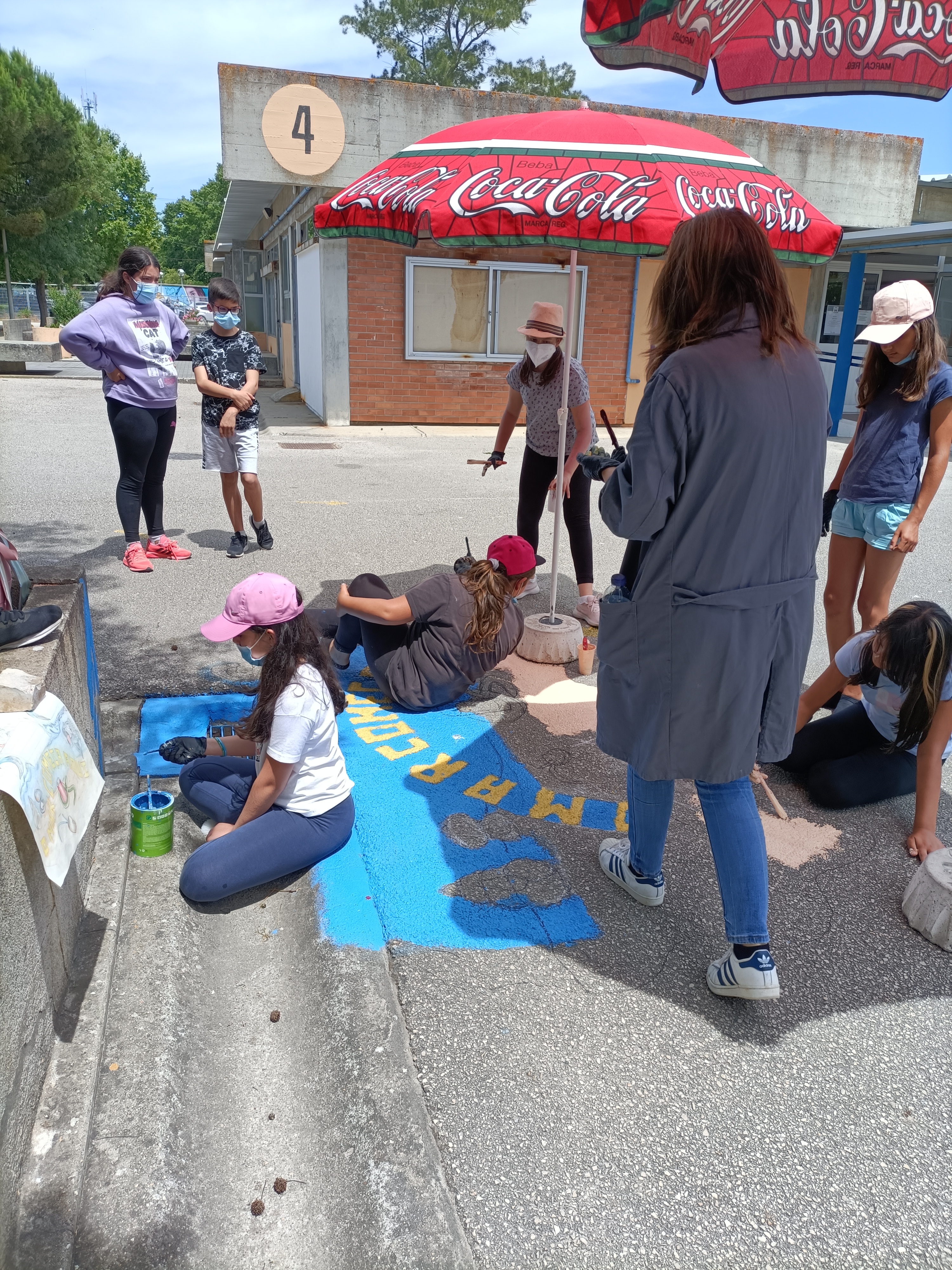 Continuação do trabalho. Os alunos pintam o chão de azul, simbolizando o Mar, sob a orientação da professora de Oficina de Artes,