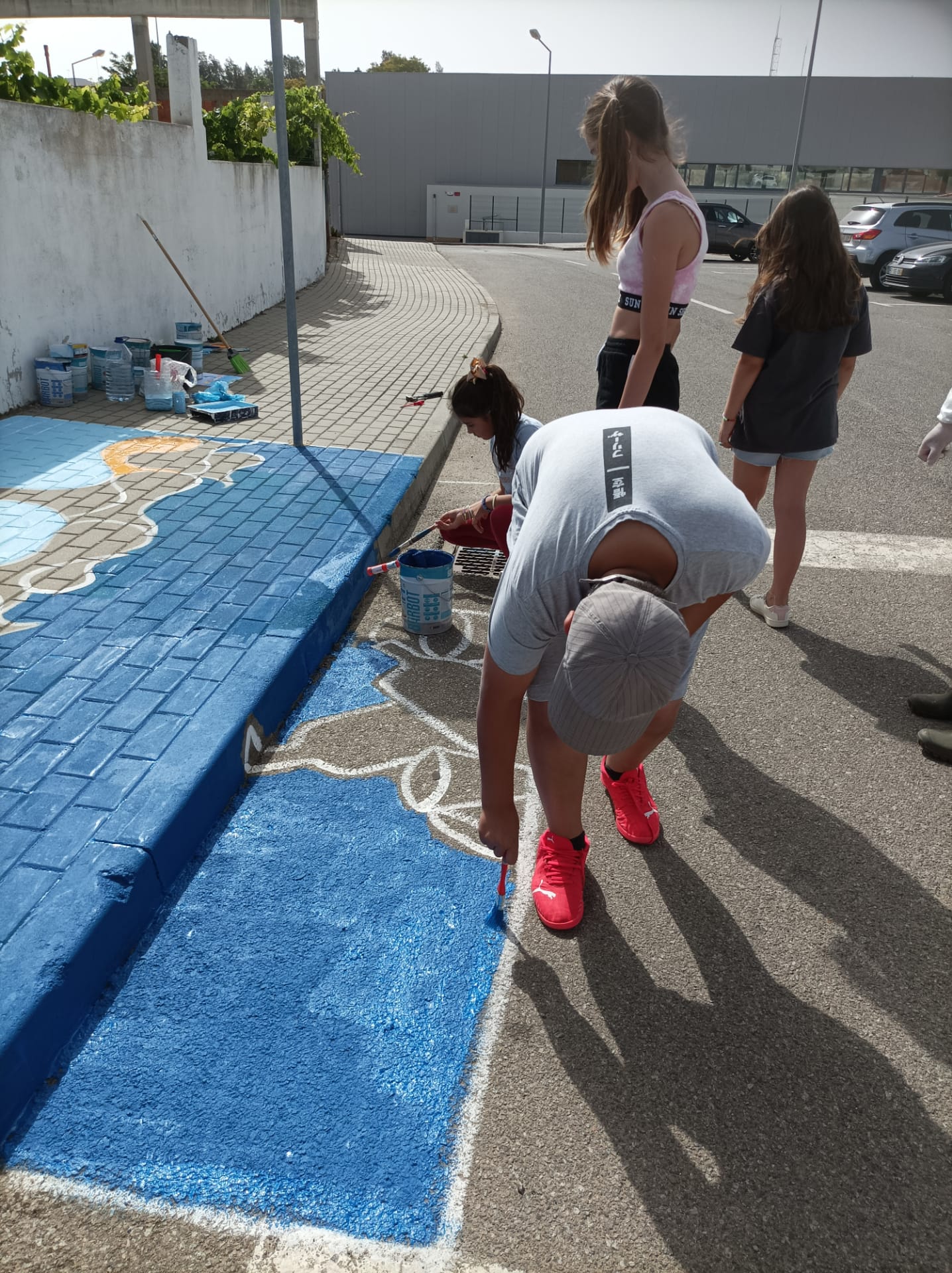 Os alunos do 5.º A a ajudarem na pintura da sarjeta.